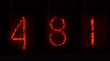 Cihazın üzerindeki vakum tüpü görüntüsü saniyeleri sayıyor. Vintage lamba zamanlayıcısında numaralar gösteriliyor, yakın çekim, nixie tüpü göstergesi. Parlama deşarj göstergesi