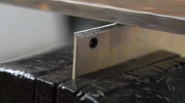 Zanaatkar, garaj atölyesindeki çalışma masasında mengeneye sıkıştırılmış metal bir dosya ile küçük metal parçası üzerinde çalışır. Kendin yap, konsepti kapat.