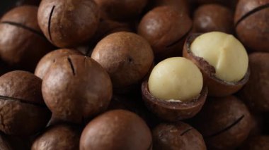 Tahta kasede kabukları olan Macadamia fındıkları, yakın, döner