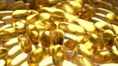 Omega 3 ve beyaz arka planda D vitamini içeren balık yağı kapsülleri, yakın plan, dönüyor. Jelatin kapsüllerde altın balık yağı