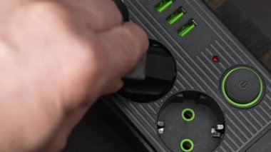 Prize bir elektrik prizi tak. Elektrik kaynağını siyah güç şeridinin düğmesine basarak kapat, kapat. Tasarruf kavramı. Elektrik aşırı yükleme fikri. Bağlı siyah tıpa