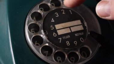 Eski usul bir telefondan numara çeviren bir adam. Döner kadranlı Retro telefon. Eski tarz telefon, yakın çekim.