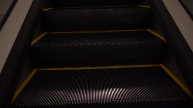 Merdiven boşluğunun yakın plan görüntüsü. Modern yürüyen merdiven, havaalanı terminalinde hareket ediyor.