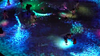 SINGAPORE CITY, SINGAPORE - MARCH 29, 2019: Large screen augmented reality experience on the floor. Children playing on Digital Light Canvas at Marina Bay Sands mall in Singapore