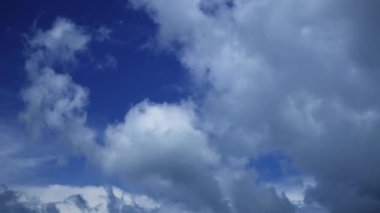Beyaz bulutlar ve mavi gökyüzü zaman kayması, yavaş hareket eden bulutlar. Yaz gününde kabarık beyaz bulutlar