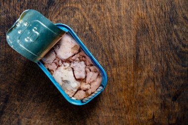 Ahşap masa arkasında morina ciğeri olan teneke kutuyu aç, üst görünümü kapat, boşluğu kopyala