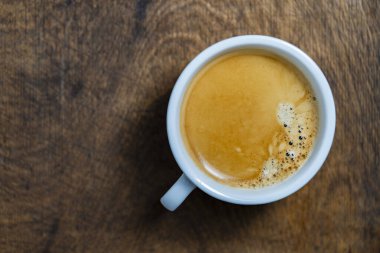 Tahta arka planda beyaz fincanda koyu bir kahve, üst manzara, kapat, boşluğu kopyala