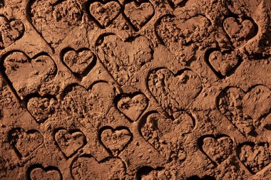 Doğal koyu kahverengi kakao tozu, üzerinde kalp resmi, desenli arka plan, yakın plan, üst görünüm.