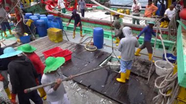 Kota Kinabalu, Malaysia - february 18, 2020 : Malaysian fishermen load freshly caught fish from a ship into plastic containers on the street philippine market in Kota Kinabalu, Sabah, Malaysia