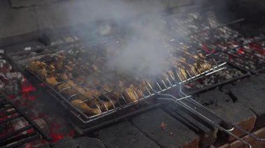 Şefimiz, Mısır 'ın Sharm el Sheikh kentindeki bir restoranda tatil yapan turistler için açık ateşte kokulu tavuk bacakları hazırlıyor.