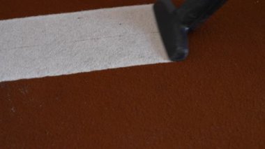 Kuru temizlemeci, kirli halıdaki kiri temizliyor. Süpürge, kirli zemini profesyonel ekipmanlarla kaplıyor.