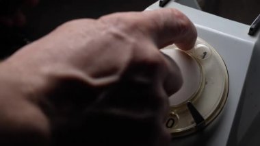 Eski usul bir telefondan numara çeviren bir adam. Döner kadranlı Retro telefon. Eski tarz telefon, yakın çekim.
