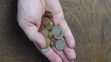 Avro paralarını sayıp el ele tutuşan erkekler, yaklaşın. Ellerinde farklı değerlerde avro sikkeleri var. Enflasyon, satın alma gücü ve sosyal kriz
