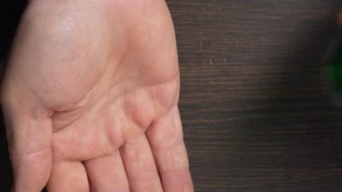 Kıdemli adam balık yağı kapsülünü elden ele dolduruyor, kapalı alanda, yakın mesafeden. Omega 3 ve D vitamini içeren altın balık yağı kapsülü. Doğal tıp, sağlıklı yaşam tarzı ve beslenme konsepti.