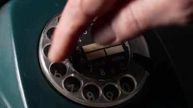 Eski usul bir telefondan numara çeviren bir adam. Döner kadranlı Retro telefon. Eski tarz telefon, yakın çekim.