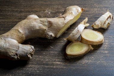 Tahta kesme tahtasıyla zencefil kökü kesip parçalara ayırmak.