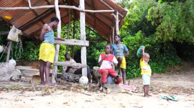 Zanzibar, Tanzanya - 16 Kasım 2019: Afrikalı erkek ve çocuklar Zanzibar, Tanzanya, Doğu Afrika kıyılarındaki gölgelerde bir gölgelik altında oturuyorlar.