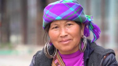 Sapa, Vietnam - Mart 02, 2020: Geleneksel kıyafet ve mücevher giyen etnik Hmong kadını Turistlerin Sapa, Kuzey Vietnam 'daki dağ köyünde el sanatları satmalarını bekliyor