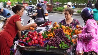 Ho Chi Minh, Vietnam - 23 Mart 2020: Vietnamlılar Ho Chi Minh, Vietnam şehir merkezindeki bir sokak gıda pazarında meyve ve sebze satıp alıyor.