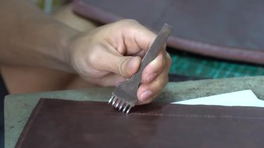 Vietnamlı zanaatkar, Hanoi City, Vietnam 'da bir sokak pazarında deri çanta yapıyor. Kapat.