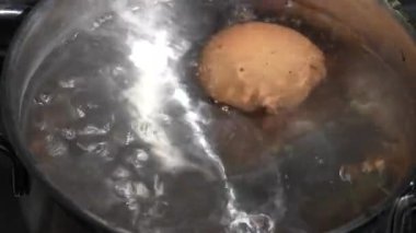 İki tavuk yumurtalı tencere, ocağın üstünde kaynar su içinde, kapat.