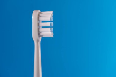 Mavi arkaplanda beyaz yeni plastik diş fırçası, kapat, kopyala