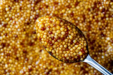 Metal kaşıkta Fransız dijon hardalı, hardal arkaplanının en üst görüntüsü. Gastronomi konsepti, organik gıda. Kapat.