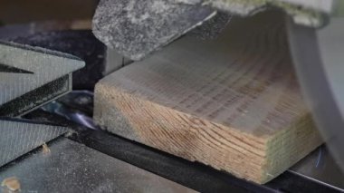 Tahta bir tahtanın kenarını kesmek için testere bıçağı, yakın çekim. Bir atölyede dairesel testere üzerinde çalışıyorum.