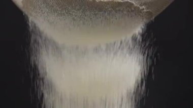 Tam buğday unu siyah arka planda bir elekten geçirilir, yavaş çekimde. Beyaz buğday unu tam tahıllı ekmek pişirmek için incelenir.