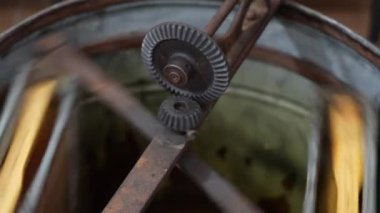 Bal sökücüdeki yuva çerçevelerinin bal peteklerinden bal özütü. Bal çerçeveleri taze organik ürün elde etmek için düzenek içinde döndürülürler. Hücrelerdeki balı döndüren elle santrifüj cihazı