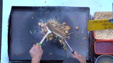 Geleneksel Çin aperatifi Chai Taw Kway ya da Malay 'daki Kuih Lobak Goreng ve İngilizce, sokak pazarında kızarmış turp keki pişiren adam.
