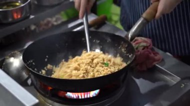 Malezyalı erkek satıcı, Malezya 'daki Kota Kinabalu, Borneo Adası' ndaki sokak yemekleri pazarında büyük bir kızartma tavasında pilav pişiriyor.