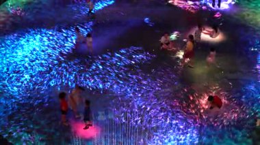 SINGAPORE CITY, SINGAPORE - MARCH 29, 2019: Large screen augmented reality experience on the floor. Children playing on Digital Light Canvas at Marina Bay Sands mall in Singapore