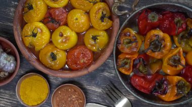 Fırınlanmış kırmızı ve sarı domates ve dolmalık biber. Ahşap bir masada fırın kabında domates ve dolma biber. Sağlıklı ve lezzetli bir vejetaryen yemeği. Kapat, üst görünüm, döndür