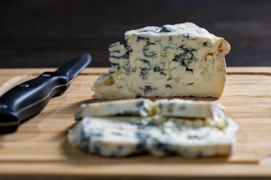 Ahşap bir tahta ve bıçak üzerinde mavi peynirli dorblu parçalar. Yaklaş. Lezzetli mavi peynir