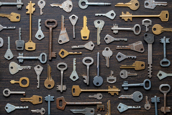 Set of different old keys on wooden background, top view, close up. Safety and security concept. Pattern of many keys