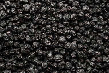 Kurutulmuş yaban mersini arka planı, yakın plan, üst manzara, makro. Kurutucudan bir yığın kuru yaban mersini. Kış için vitamin ve sağlıklı beslenme kavramı