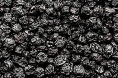 Kurutulmuş yaban mersini arka planı, yakın plan, üst manzara, makro. Kurutucudan bir yığın kuru yaban mersini. Kış için vitamin ve sağlıklı beslenme kavramı