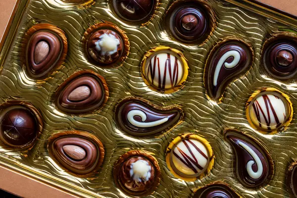 Karmaşık, koyu ve sütlü çikolatalı şekerler kutuda, yakın çekim, üst manzara