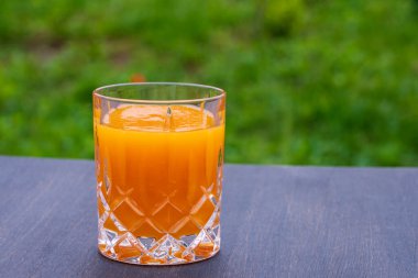 Sağlıklı balkabağı meyveli smoothie cam üzerinde ahşap masa karşı doğa arka planı, yakın