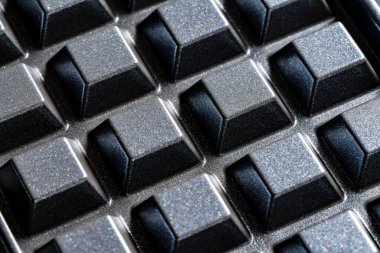 Siyah waffle çubuksuz alüminyum tabaklar tasarım amaçlı, yakın çekim. Arkaplan ya da doku olarak waffle makinesi tabağı