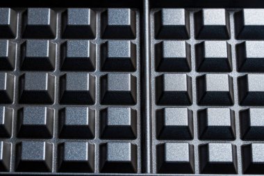 Siyah waffle çubuksuz alüminyum tabaklar tasarım amaçlı, yakın çekim. Arkaplan ya da doku olarak waffle makinesi tabağı