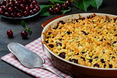 Lezzetli vişneli turtayla pişirme tabağı, yakın çekim. Tahta masada taze kırmızı kirazlı nefis ev yapımı turta. Böğürtlenli kısa hamurlu turta