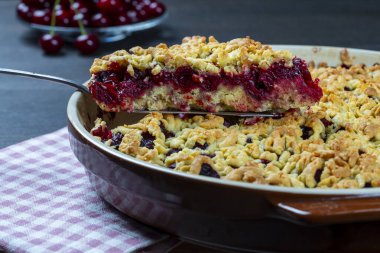 Lezzetli vişneli turtayla pişirme tabağı, yakın çekim. Tahta masada taze kırmızı kirazlı nefis ev yapımı turta. Böğürtlenli kısa hamurlu turta