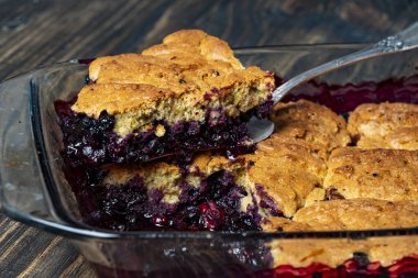 Tatlı kaşığında taze pişmiş yaban mersinli tart, yakından. Ev yapımı meyveli turta yemeye hazır.