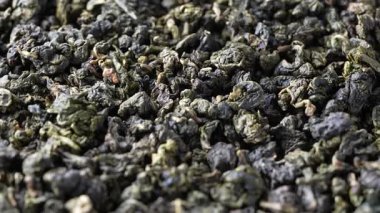 Süt aromalı yeşil çay yapraklı oolong. Yaklaş. Kurumuş yeşil çay yapraklarının arka planı, dönüşler, makro