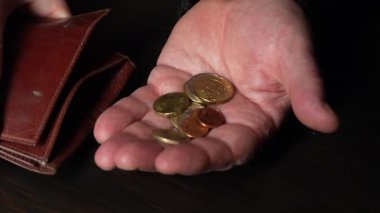 Avro paralarını tutan ve sayan yaşlı erkek eller, yaklaşın. Ellerinde farklı değerlerde avro sikkeleri var. Enflasyon, satın alma gücü ve sosyal kriz