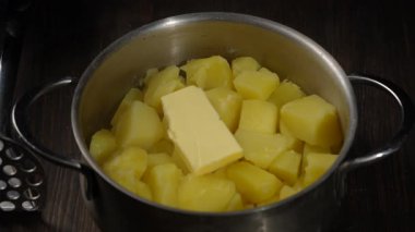 Tahta bir masada metal eziciyle ezilmiş taze patates püresi. Yakın çekim.