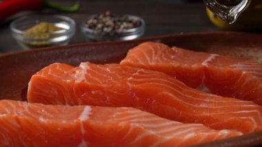 Pişirmek için çiğ somon filetosunun üzerine zeytinyağı dök. Yavaş çekimde. Sağlıklı beslenme