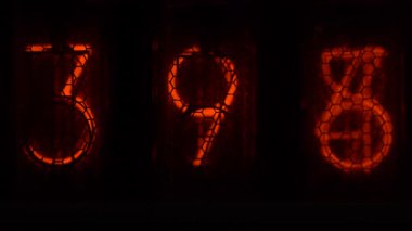 Cihazın üzerindeki vakum tüpü görüntüsü saniyeleri sayıyor. Vintage lamba zamanlayıcısında numaralar gösteriliyor, yakın çekim, nixie tüpü göstergesi. Parlama deşarj göstergesi